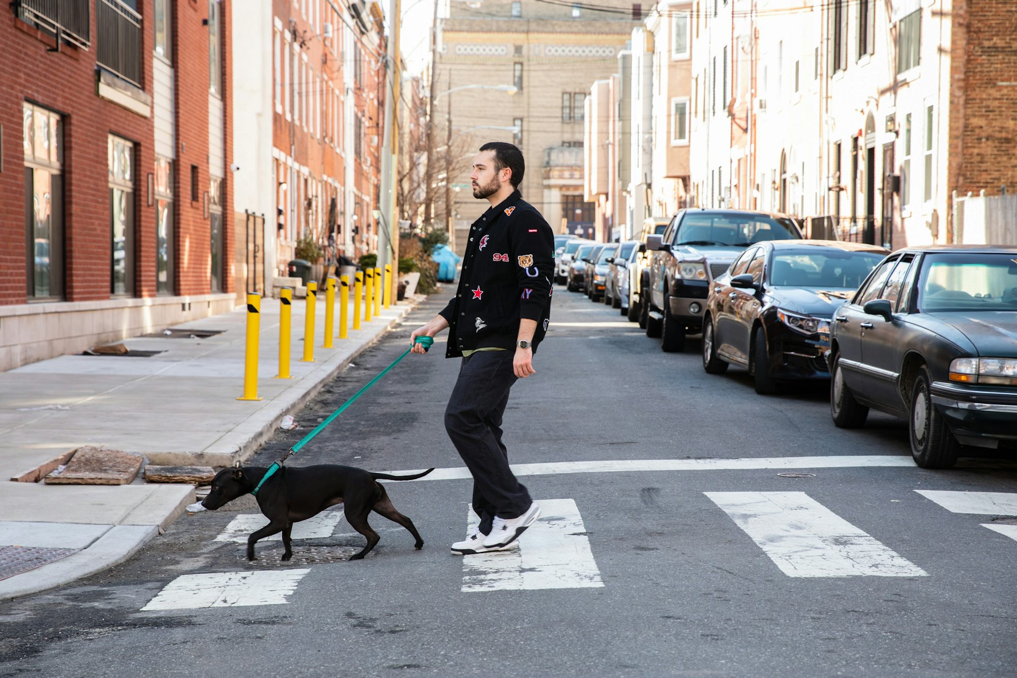 A man and a dog crossing a street