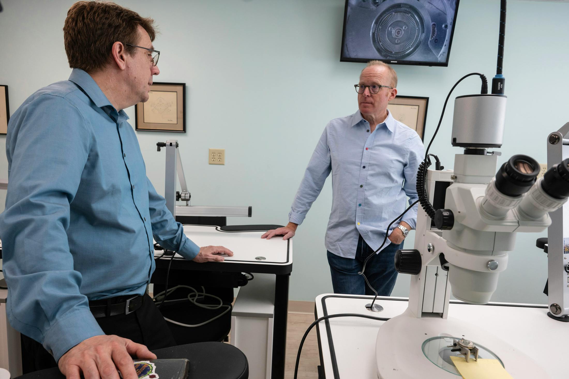 NAWCC Executive Director, Rory McEvoy (left) and Roger Smith, discuss the microscopic projector in the NAWCC School of Horology