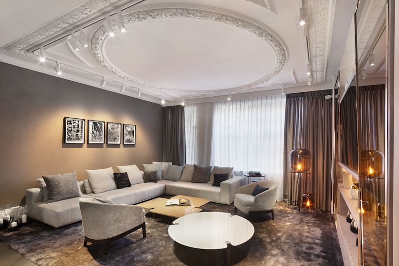 A luxurious room with a large sectional sofa and many candles 
