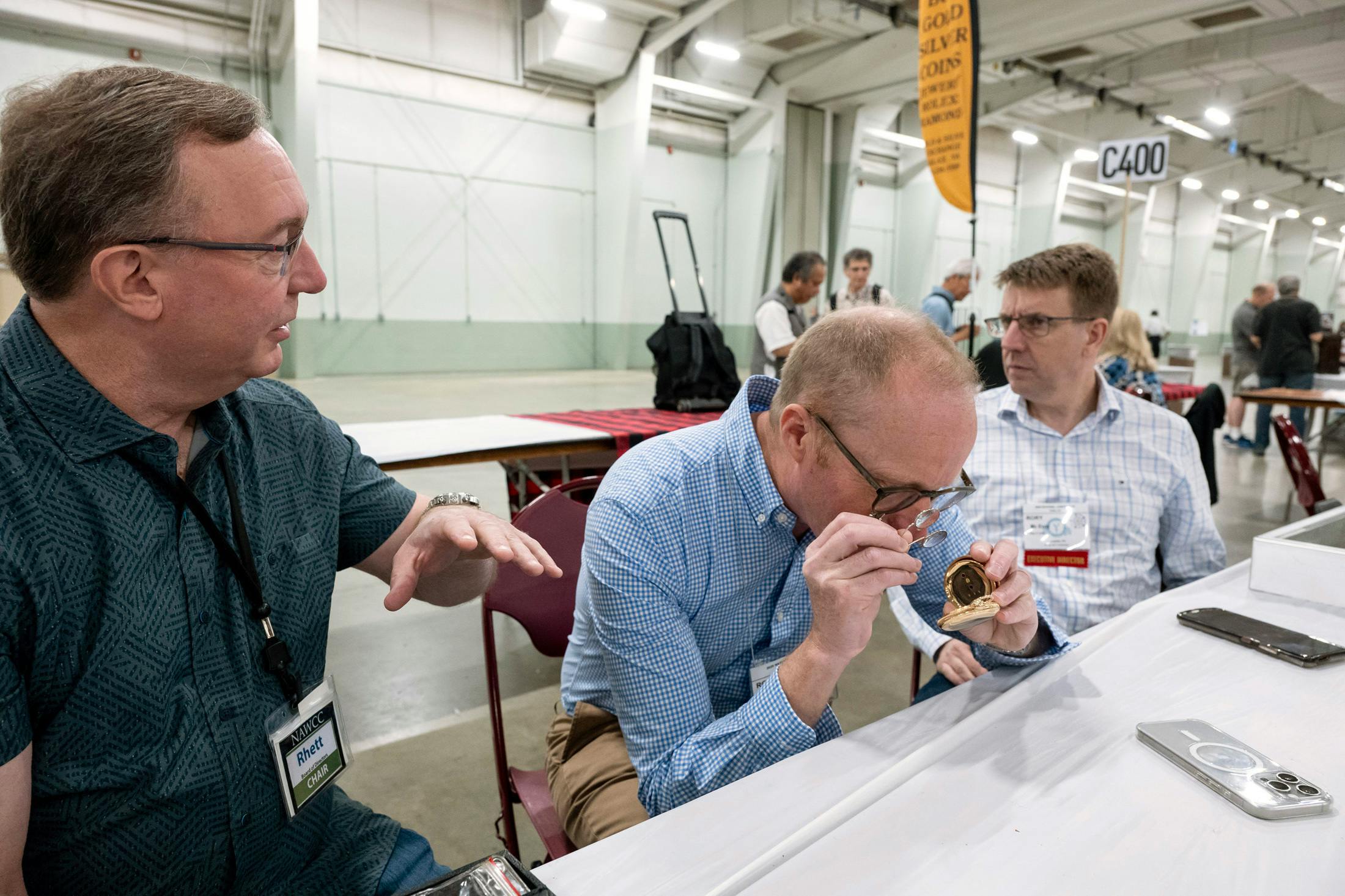 Former NAWCC Board Chair Rhett Lucke (left) shares details with NAWCC Executive Director Rory McEvoy (Right) as Roger Smith examines a Charles Fasoldt pocket watch at the NAWCC National Convention in York, PA