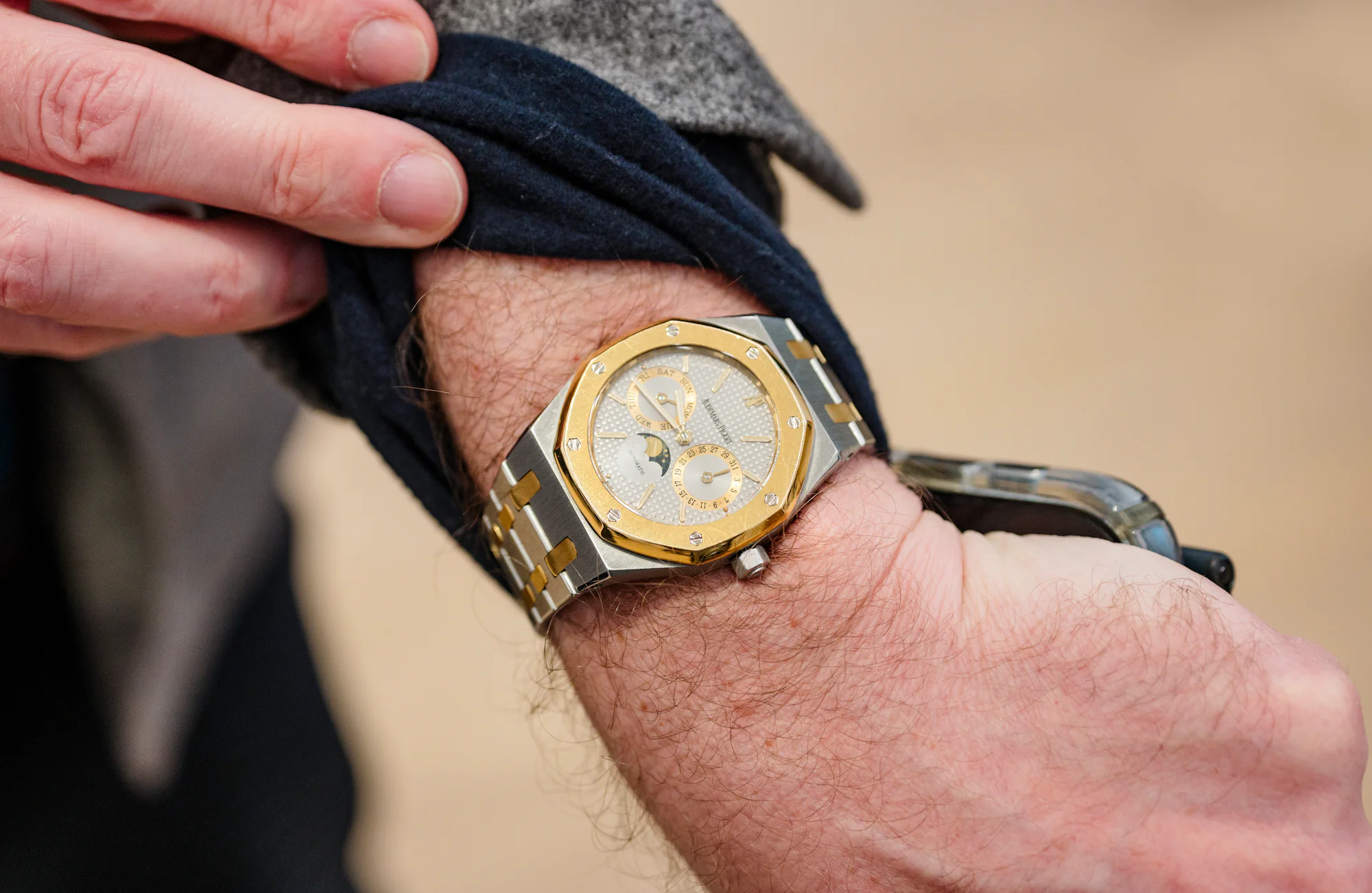 A man wears an Audemars Piguet Royal Oak Perpetual Calendar Two Tone and holds his sleeve up.