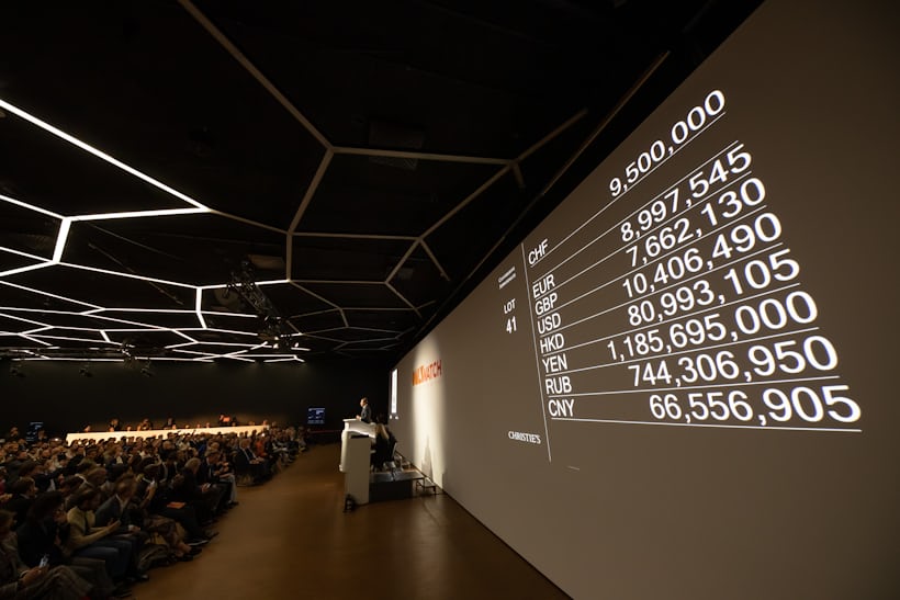 A wall projection captures the bidding process in different currencies at Only Watch 2021.
