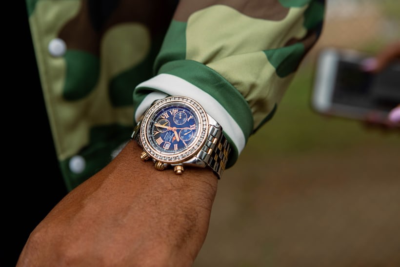 A person wearing watch and a camo jacket