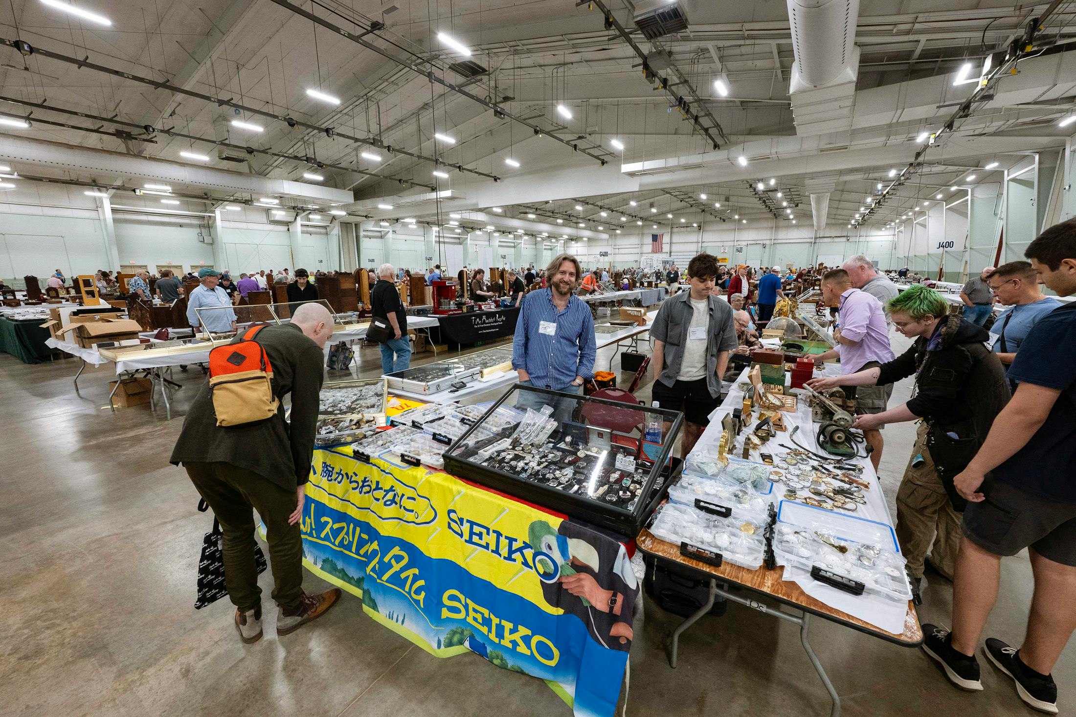 Some early entrants examine the goods on one of over 500 mart tables at the NAWCC National Convention in York, PA