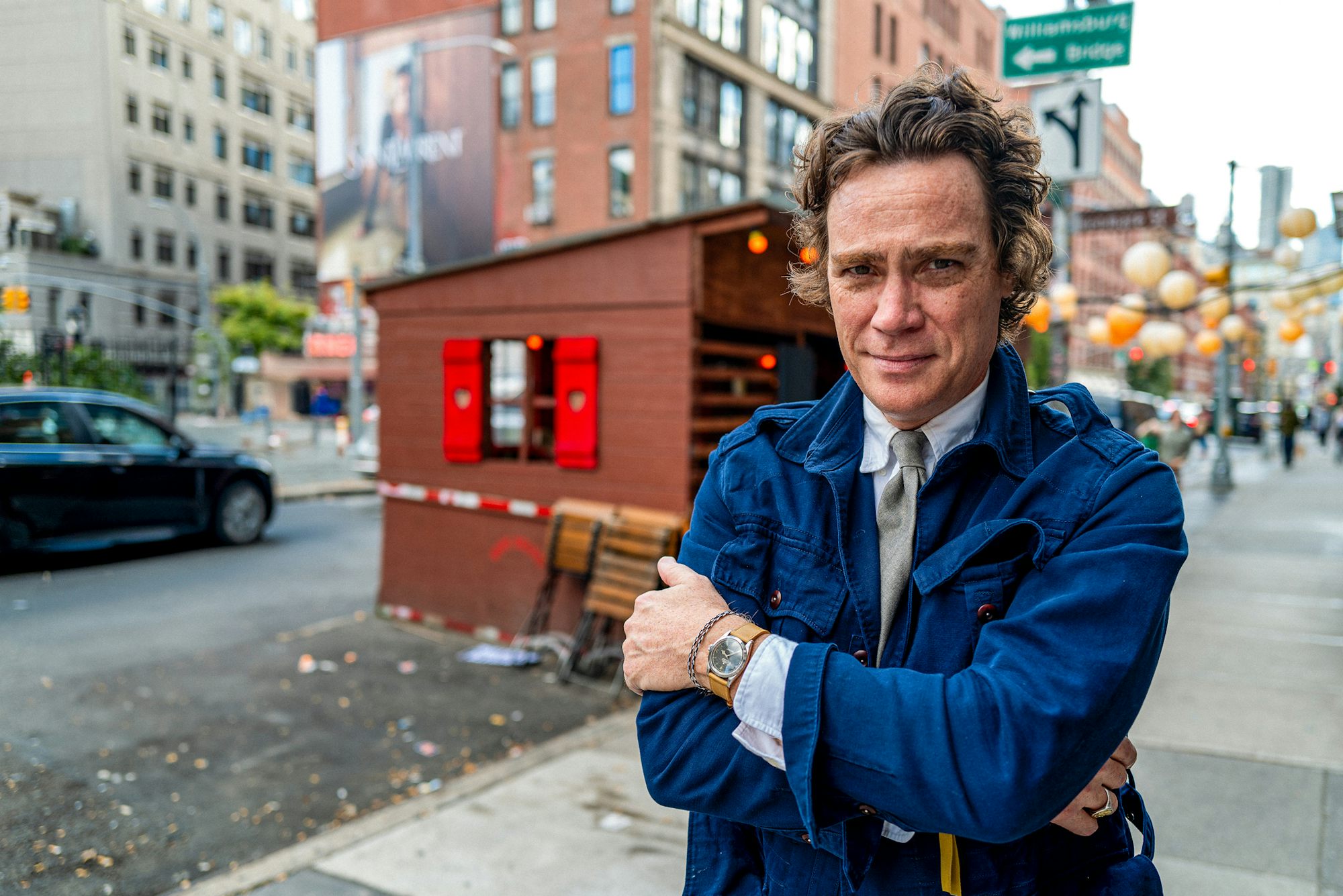 Jay Fielden crosses his arms and stands on an NYC street corner in SoHo while wearing a Rolex watch
