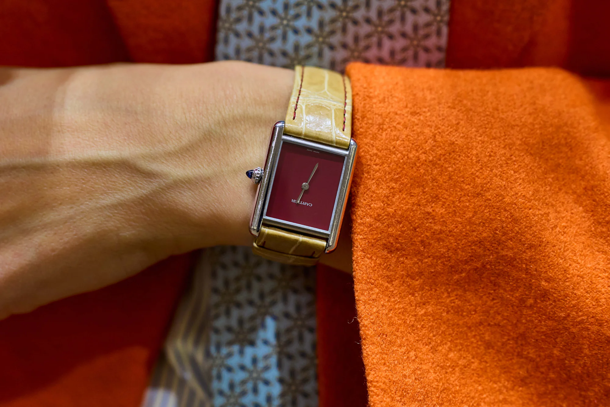Wearing a Cartier Tank Must with red lacquer dial.