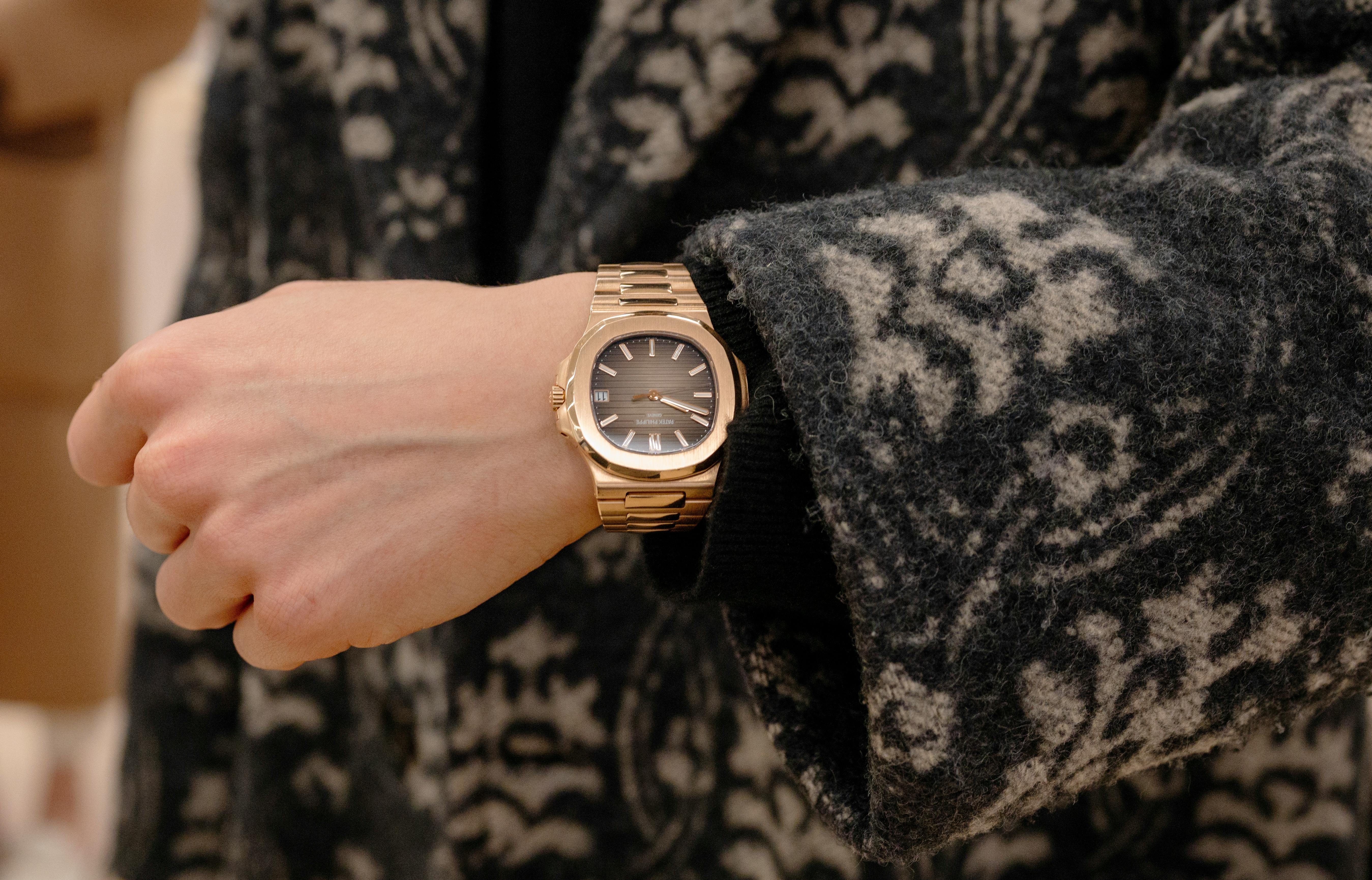 A man wears a gold Patek Philippe Nautilus. 