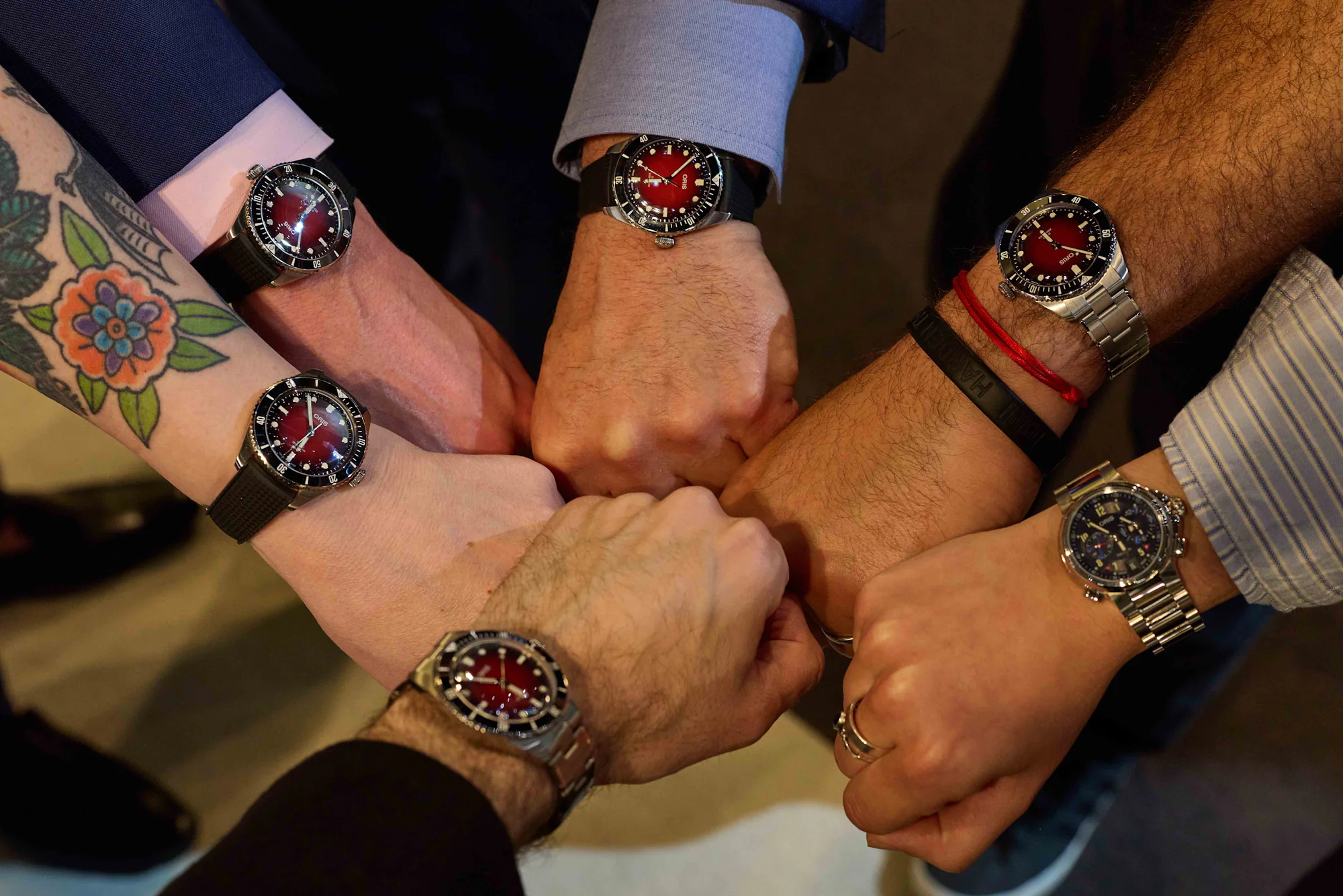 A gaggle of Oris X RedBar Limited Edition IIs and the wrist of the designer behind it