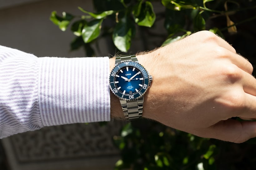 An Oris Aquis Date Caliber 400 with a blue dial on a man's wrist.