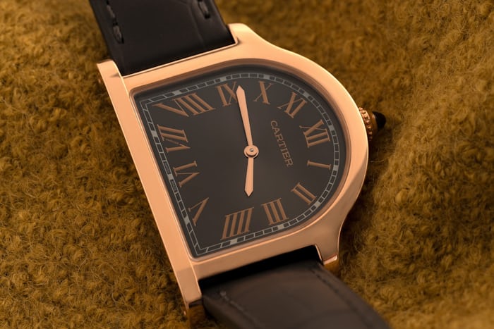 Cartier Cloche watch on a mustard background