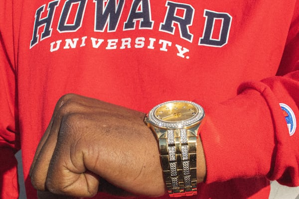 A person wearing a Howard sweatshirt and a watch
