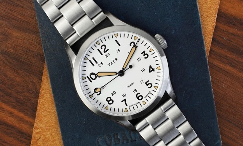 A white dial field watch on a bracelet.
