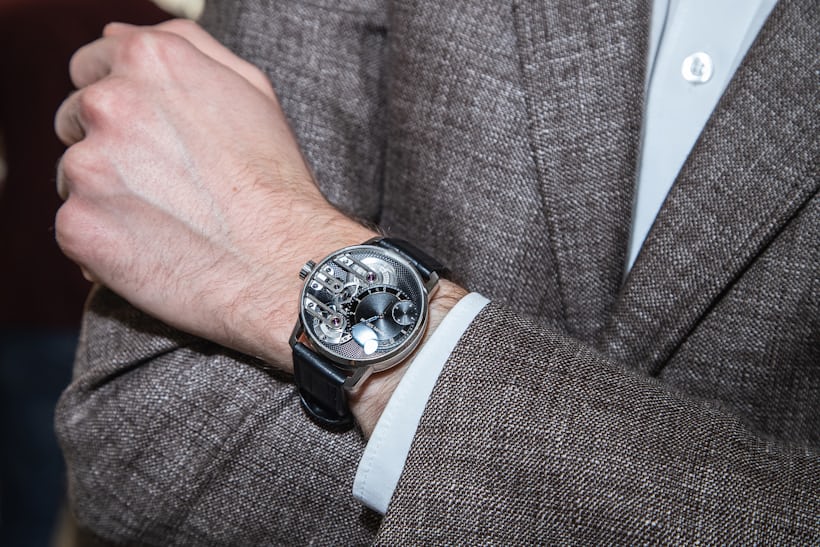 A person wearing a watch and suit