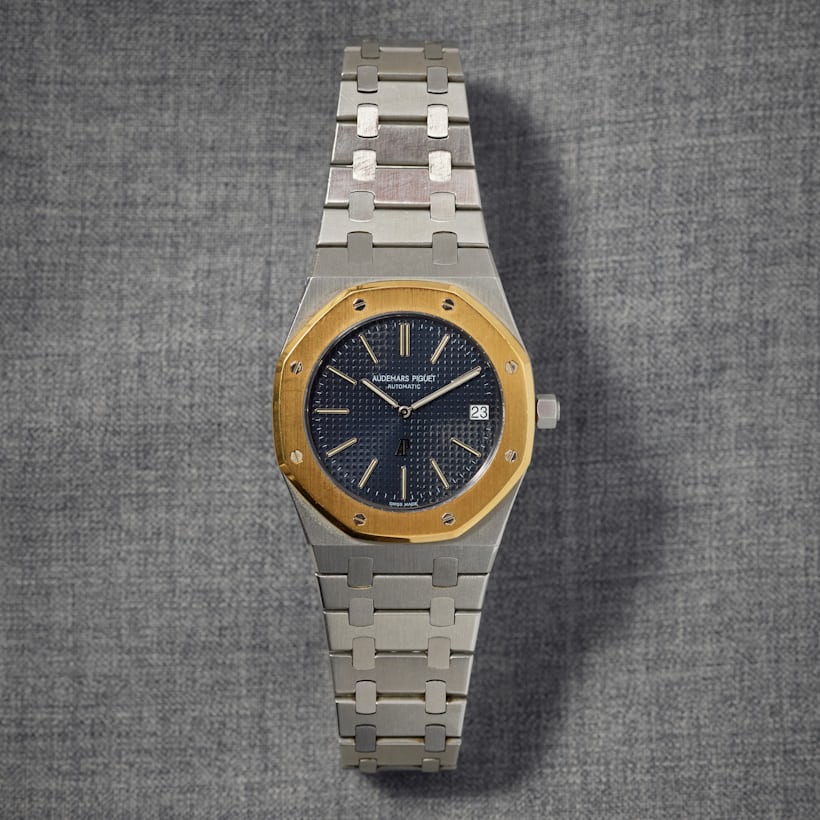 A two-tone Audemars Piguet Royal Oak 5402A laying on a grey background. 