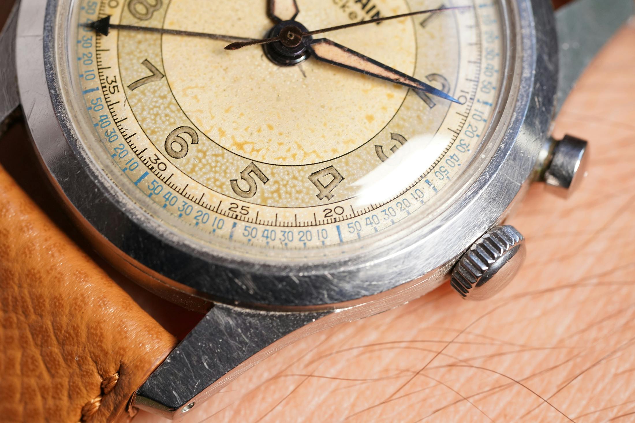 A close up of the crown of a Vulcain Cricket watch