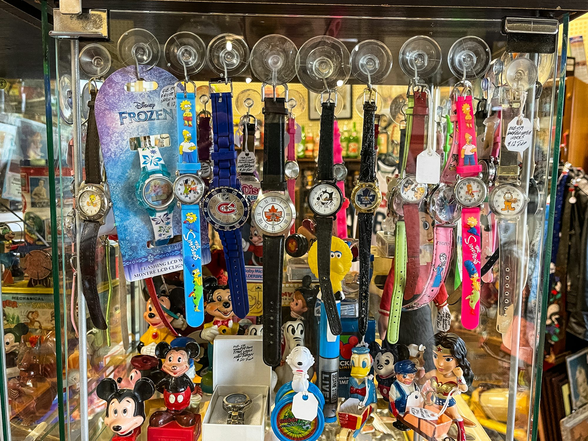 A cabinet with several hockey and disney themed watches. 