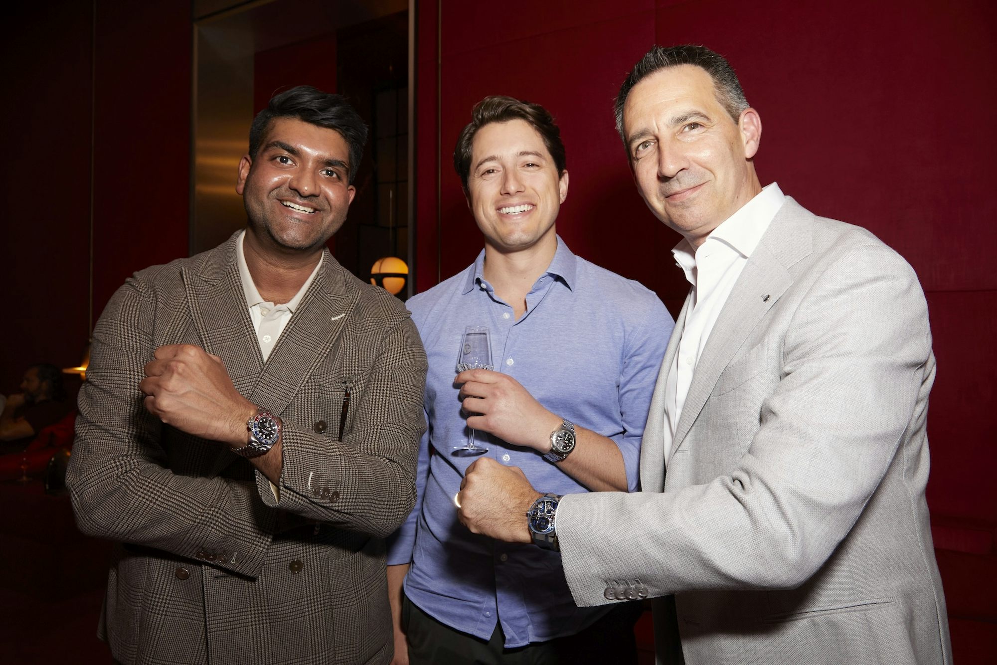 Three men pose and show off their watches