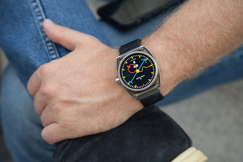 A person wearing a watch with colorful hands