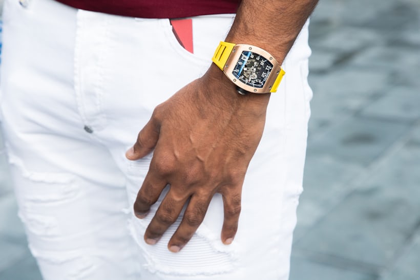 A person wearing a Richard Mille watch and white pants