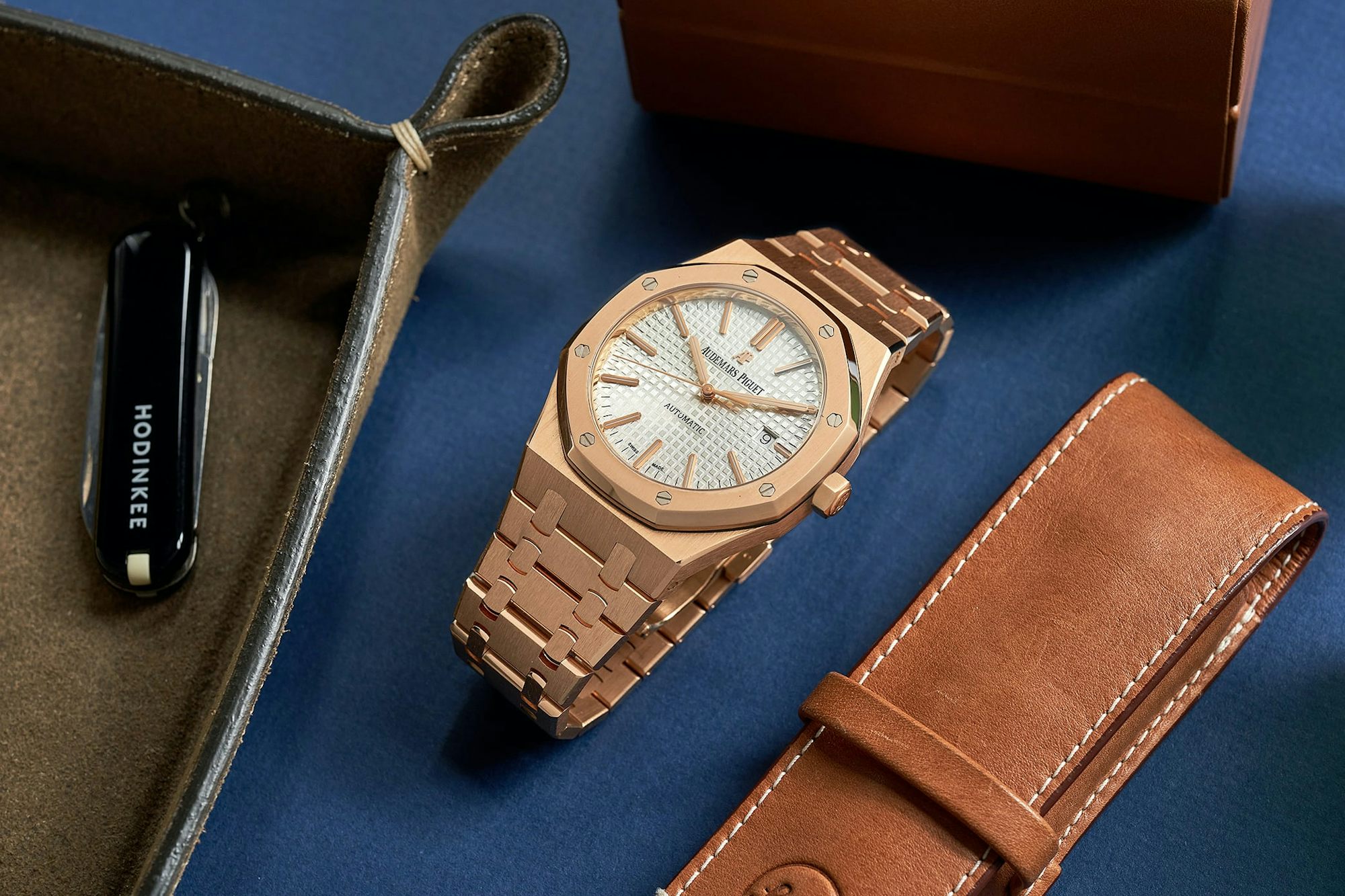 The gold dress of the Audemars Piguet Royal Oak is next to a leather tray