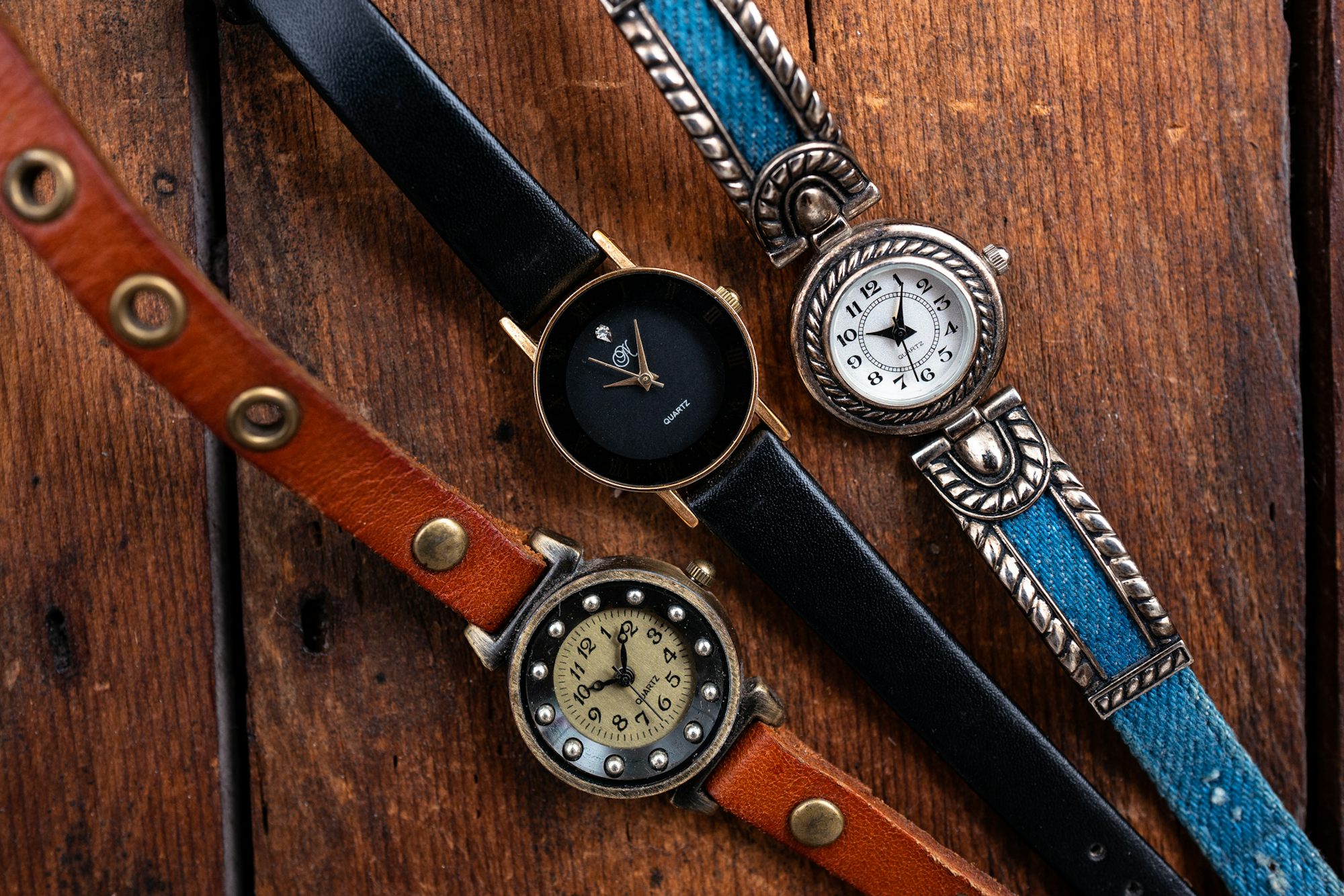 Three inexpensive ladies watches from the bag on a table. 
