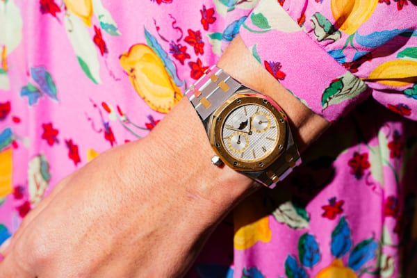 A person wearing a watch and a patterned dress